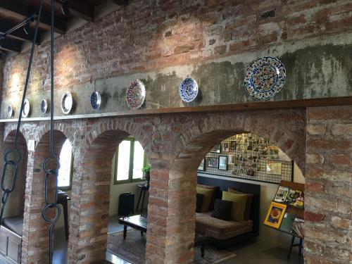 a room with a brick wall with plates on it at Spices Hotel in George Town