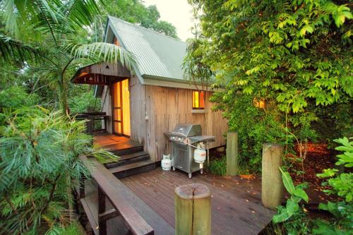 a small cabin with a deck in the woods at Mt Glorious Getaways in Mount Glorious