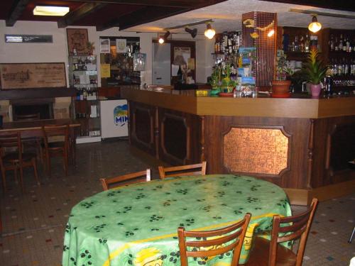 a dining room with a table and a bar at Auberge du Meygal in Champclause
