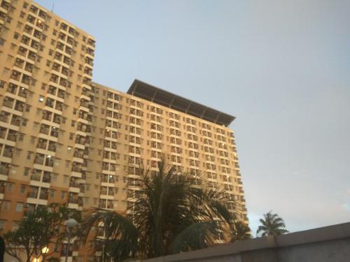 a tall building with palm trees in front of it at DSR Apartment Margonda Residence 2 in Depok