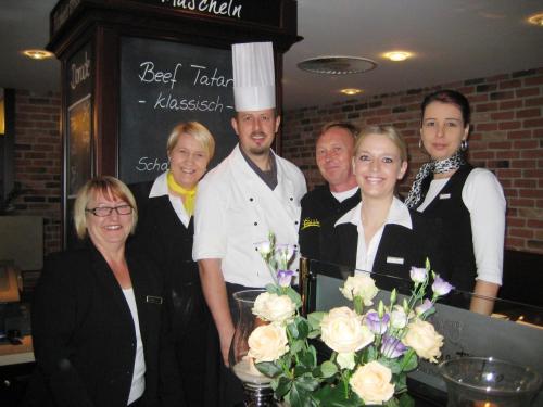 a group of people posing for a picture in a restaurant at Europa Hotel Kühlungsborn in Kühlungsborn
