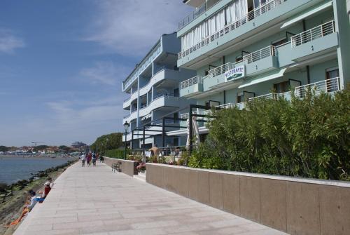a building on the beach next to the water at Hotel Marea in Grado