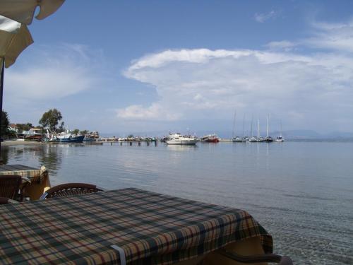 a table with a checkered table cloth next to the water with boats at Pension Elena in Ágios Nikólaos