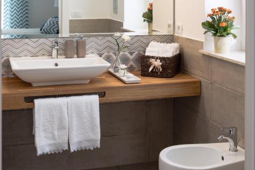 a bathroom with a sink and a mirror and towels at Zenzero e Limone in Siracusa