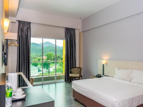a hotel room with a bed and a large window at MH Sentral Hotel Sg Siput in Ipoh