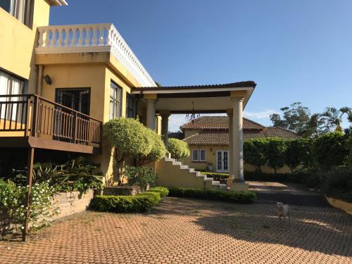 een huis met een veranda en een kat ervoor bij Edens Guest House in Durban