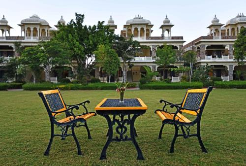 two chairs and a table in front of a building at The Udaibagh in Udaipur