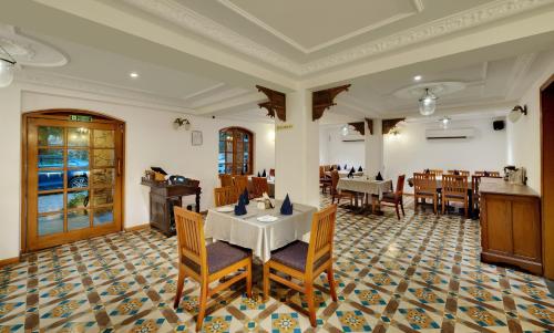Un comedor con mesas y sillas en un restaurante. en WelcomHeritage Mani Mansion, en Ahmedabad