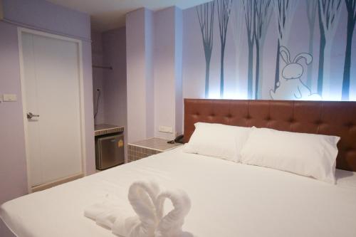 ein Schlafzimmer mit einem weißen Bett mit einem Schwan darauf in der Unterkunft Rabbit Room in Bangkok