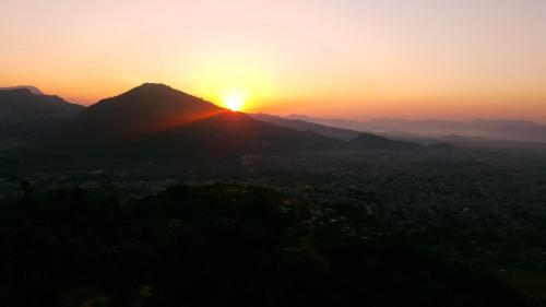 a sunset over a mountain with the sun setting at Himalayan Front Hotel by KGH Group in Pokhara