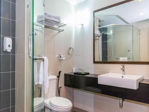 a bathroom with a sink and a toilet and a mirror at MH Sentral Hotel Sg Siput in Ipoh