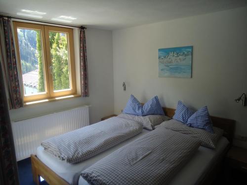 2 Einzelbetten in einem Schlafzimmer mit Fenster in der Unterkunft Pension Susanne in Sankt Anton am Arlberg