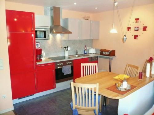 a kitchen with a red refrigerator and a wooden table at Fewo B am Kurpark in Willingen