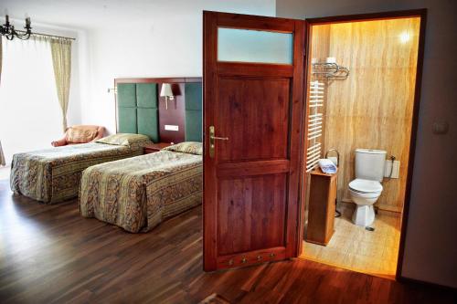 a room with two beds and a door with a toilet at Zamek w Dzięgielowie in Dzięgielów