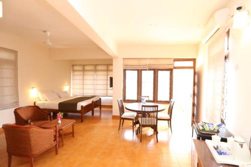 a living room with a bed and a table and chairs at Abad Serviced Villas in Kovalam
