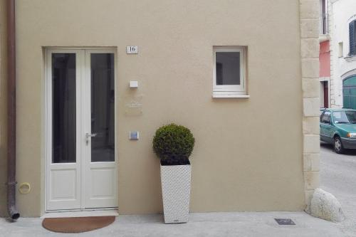 a building with a door and a potted plant next to it at Vicolo Fiore Affittacamere in Matera