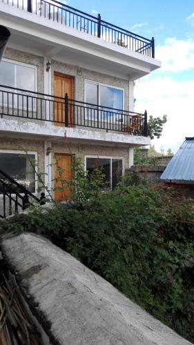 a house with a balcony on top of it at Kevin's Trekker Inn in Shangri-La