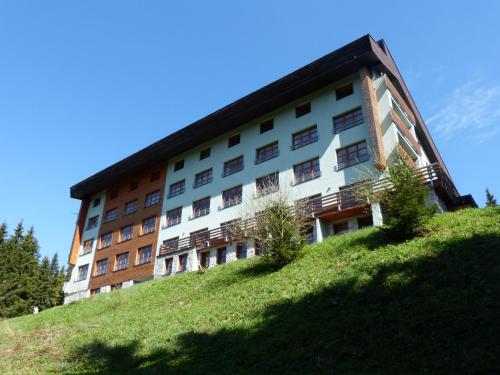 a building on top of a grassy hill at Apartmán v Srdci Hor Cihlářka in Pec pod Sněžkou