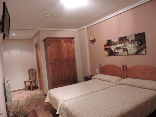a bedroom with a bed and a dresser at Hostal Villa de Navarrete in Navarrete