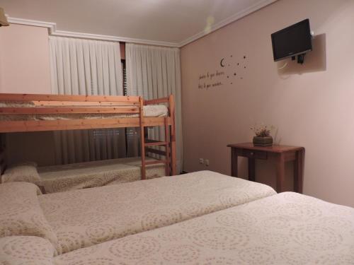 a bedroom with a bed and a tv at Hostal Villa de Navarrete in Navarrete