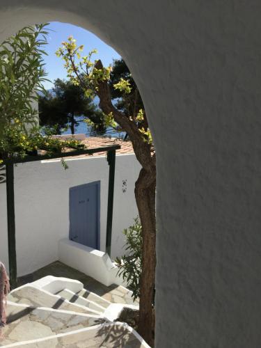 an archway with a tree and a blue door at Rosys Little Village in Skala