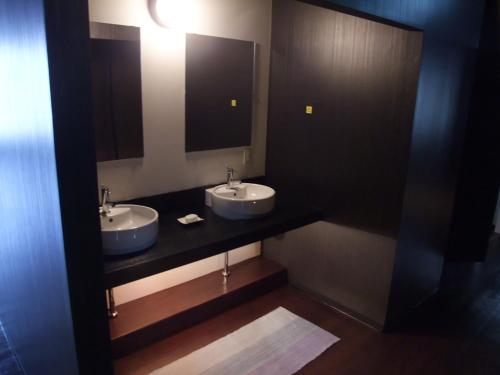 a bathroom with two sinks and a mirror at International Guesthouse Azure Narita in Narita