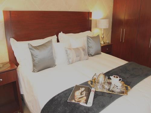 a hotel bed with a tray of items on it at Keret Accommodation in Bellville
