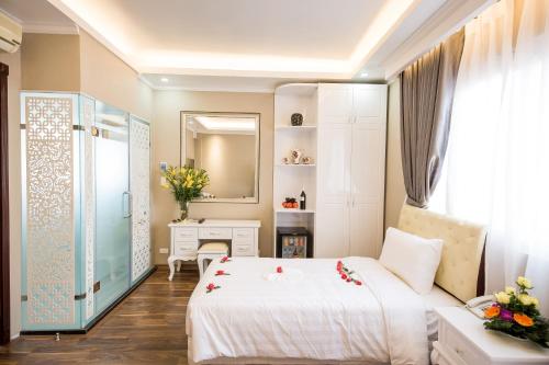 a bedroom with a bed and a desk and a mirror at Little Hanoi Deluxe Hotel in Hanoi