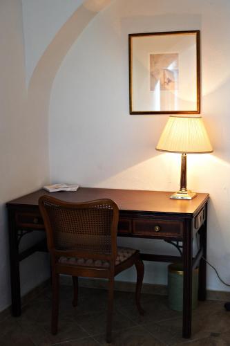 a desk with a lamp and a chair at Zamek w Dzięgielowie in Dzięgielów
