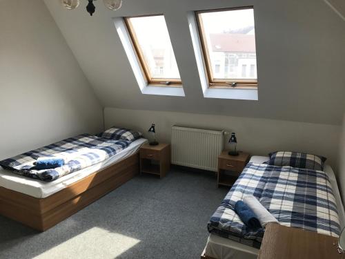2 Betten in einem Zimmer mit 2 Fenstern in der Unterkunft Penzión Dobré Časy in Košice