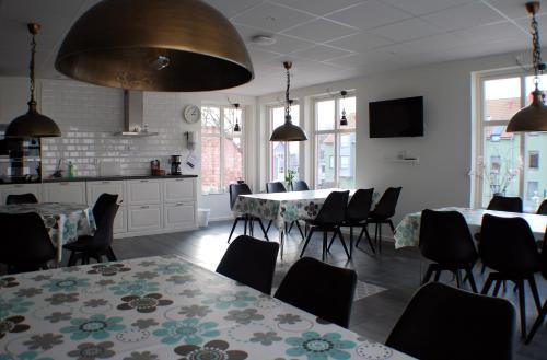 a dining room with two tables and chairs and windows at Go to sleep Arvika in Arvika