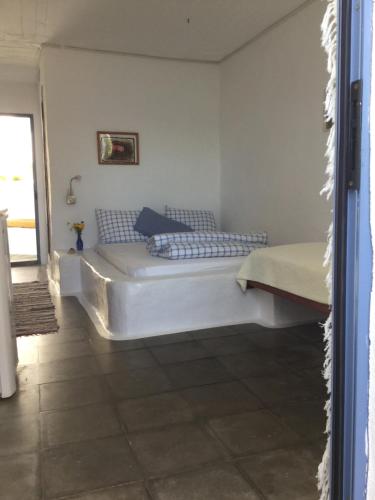 a bedroom with a white bed in a room at Rosys Little Village in Skala