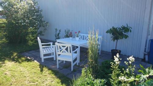 a white table and two chairs on a patio at Tossene Vandrahem in Hunnebostrand