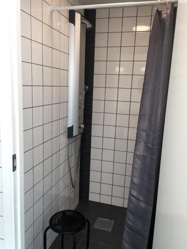 a small bathroom with a shower with a stool at Go to sleep Arvika in Arvika