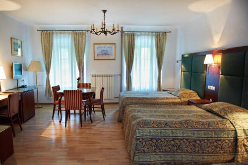 a hotel room with two beds and a table and chairs at Zamek w Dzięgielowie in Dzięgielów