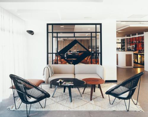 salon z kanapą, krzesłami i pianinem w obiekcie Hôtel & Spa Villa Seren w mieście Soorts-Hossegor
