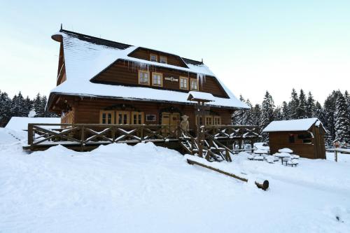 a log cabin with snow on the roof at Koliba u Kuba a rekreačné domy in Hruštín
