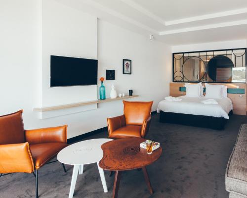 a hotel room with a bed and a table and chairs at Hôtel & Spa Villa Seren in Hossegor