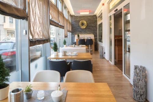 un restaurante con mesas y sillas de madera y ventanas en Hotel Isartor en Múnich
