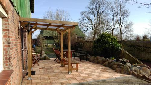 a wooden pergola on a patio with a table and chairs at Fewo Bendig in Neuendorf-Sachsenbande