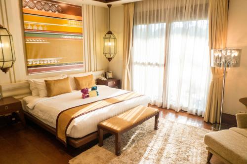 a bedroom with a large bed and a large window at Sibsan Luxury Hotel Rimping in Chiang Mai