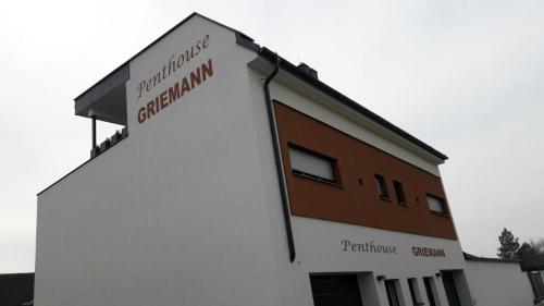 a white building with a sign on the side of it at PENTHOUSE Griemann 2 für max 4 Personen mit eigener großer Dachterrasse zum Relaxen! in Illmitz