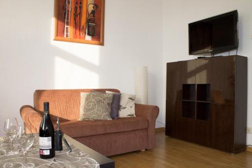 ein Wohnzimmer mit einem Sofa und einem Tisch mit Weinflaschen in der Unterkunft Ferienwohnung Ohligs in Solingen