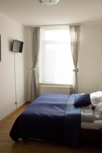 a bedroom with a blue bed and a window at Ferienwohnung Ohligs in Solingen