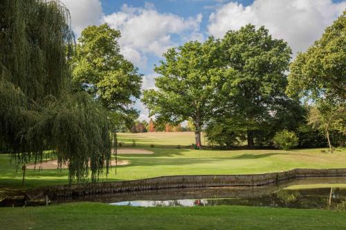 a golf course with a pond and trees at Hever Castle Luxury Bed and Breakfast in Edenbridge