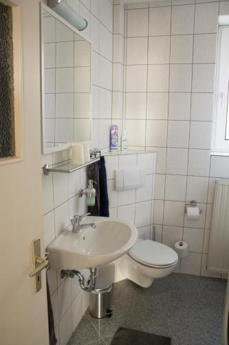 a white bathroom with a toilet and a sink at Ferienwohnung Ohligs in Solingen