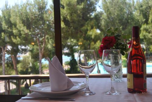 una mesa con dos copas y una botella de vino en Hotel Sancho III, en Alcossebre