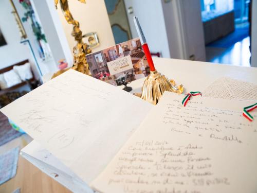 a pile of papers on a table with a pen at Casa Malena in Ascoli Piceno