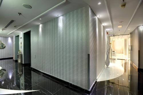 einen Flur mit einer Glaswand und einem Glastisch in der Unterkunft Broadway Hotel in Dubai