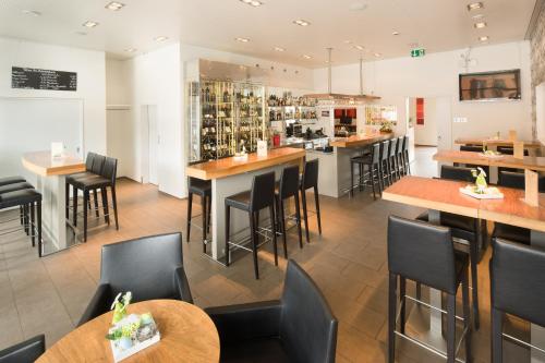 un restaurant avec des tables et des chaises ainsi qu'un bar dans l'établissement Hotel Arcade, à Sins